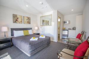 a bedroom with a bed and a living room at Greyfriars Motel in Greytown