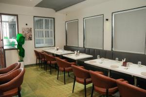 a restaurant with a row of tables and chairs at Hotel Regency Grand in Shikrapur