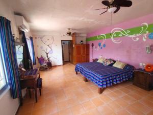 a bedroom with a bed and a purple wall at Casa Blanca Zipolite, Dream House in Zipolite