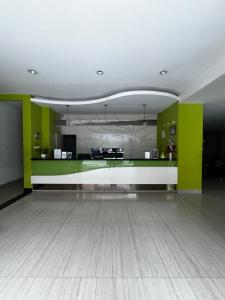 a living room with green walls and a white floor at Hotel Alden in Makassar