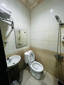 a bathroom with a toilet and a sink at Hotel Alden in Makassar