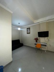 a living room with a couch and a tv at Hotel Alden in Makassar