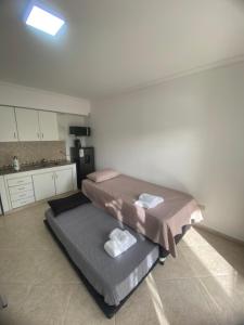 a room with two beds and a kitchen in it at Patagonico in Puerto Madryn
