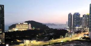 a view of a city at night with buildings at Ocean View Haute Hotel in Busan