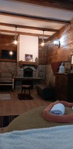 a living room with a fireplace and a stone wall at Капсъзовата къща in Leshten