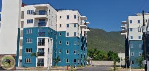 a blue and white building with a mountain in the background at Simpsons Little Gem 1 in Kingston