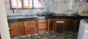 a kitchen with wooden cabinets and a sink at Temple House in Trivandrum