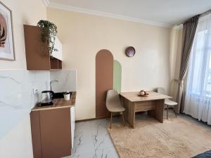 a dining room with a table and a kitchen at Bekarys Hotel in Astana