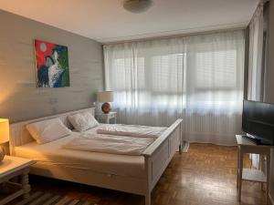 a bedroom with a white bed and a television at Villa Diana WestEnd in Frankfurt