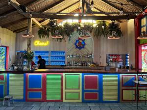 a colorful bar in a restaurant with a man behind the counter at Calm & Palms Second Floor Studio in Coco