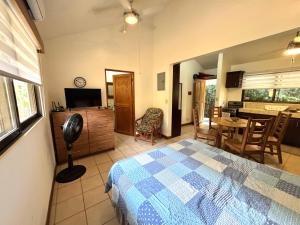 a bedroom with a bed and a kitchen with a table at Calm & Palms Second Floor Studio in Coco