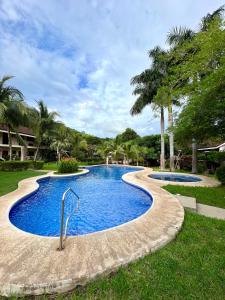 a swimming pool in a park with palm trees at Calm & Palms Second Floor Studio in Coco
