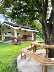 a wooden bench sitting under a tree in a park at Calm & Palms Second Floor Studio in Coco