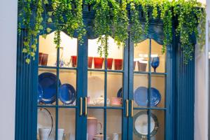 a glass cabinet with dishes and plants in it at White House, Billiard, Private Pool, Prime Location in Angeles