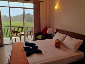a bedroom with a bed with a view of a balcony at Villa SOORYAALI in Galle