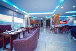 a restaurant with tables and chairs and a television at Click Collection The Abode Dharamshala in Dharamshala