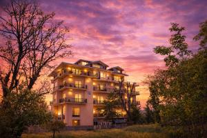 a white building with a sunset in the background at Click Collection The Abode Dharamshala in Dharamshala