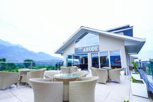 a patio with chairs and tables in front of a building at Click Collection The Abode Dharamshala in Dharamshala +34 photos