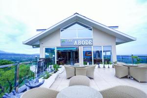 a building with tables and chairs on a patio at Click Collection The Abode Dharamshala in Dharamshala