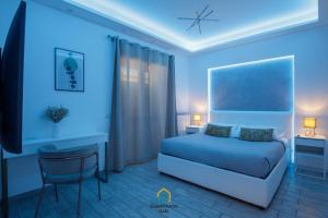 a bedroom with a bed and a desk and a tv at Coho House Fiumicino in Fiumicino +13 photos