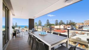 a balcony with a table and chairs and a view of the ocean at Oceans Edge #7 Accom Holidays in Terrigal