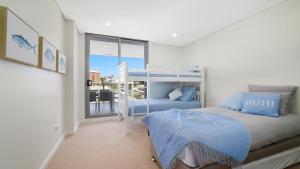 a bedroom with a bed and a large window at Oceans Edge #7 Accom Holidays in Terrigal +2 photos
