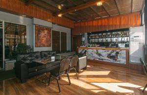 a bar with chairs and a couch in a room at RedDoorz Plus at Canley Residential in Manila