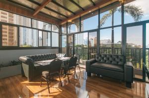 a living room with a table and chairs and windows at RedDoorz Plus at Canley Residential in Manila