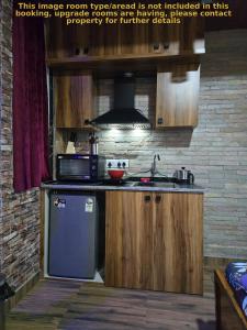 a kitchen with a refrigerator and a stove top oven at Barla's Home Stay - Mini Studio Room in Shamshabad