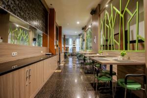 a restaurant with long tables and green chairs at Akasia Budget Hotel in Ulujami