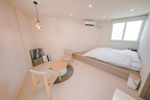 a bedroom with a bed and a table and chairs at Jeonju One Two Stay in Jeonju
