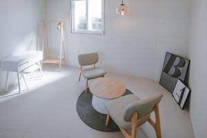 a living room with a table and a chair and a piano at Jeonju One Two Stay in Jeonju