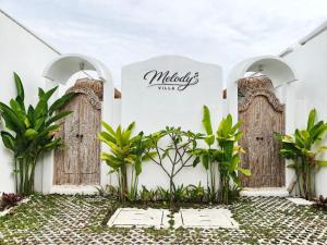 an entrance to a villa with wooden doors at Villa Melody Uluwatu by LODGELINK BALI in Badung