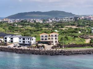 a group of houses next to a body of water at Jeju Bahama Pension in Jeju
