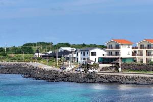 a group of buildings next to a body of water at Jeju Bahama Pension in Jeju +13 photos
