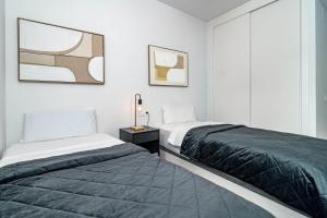 two beds in a room with white walls at EG5.4A - Luxury Penthouse with Private Sun Terrace in Estepona +26 photos