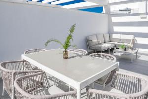 a white table and chairs with a potted plant on a patio at EG5.4A - Luxury Penthouse with Private Sun Terrace in Estepona