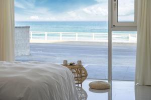 a bedroom with a bed and a view of the ocean at Gangneung The View Pension in Gangneung
