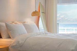 a bedroom with a bed and a window with a surfboard at Gangneung The View Pension in Gangneung +23 photos