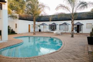 a swimming pool in the middle of a courtyard at Uitsig Boutique Hotel in Welkom