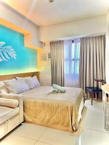 a hotel room with a bed and a table at Nico's Studio Condo in Cebu City