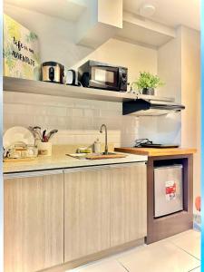 a kitchen with a sink and a microwave at Nico's Studio Condo in Cebu City