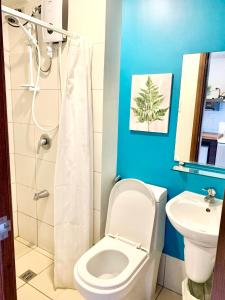 a bathroom with a toilet and a sink at Nico's Studio Condo in Cebu City