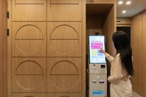 a woman is standing in front of a machine at Brown Dot Hotel Incheon Bupyeong in Incheon +37 photos
