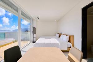 a bedroom with a bed and a view of the ocean at Geoje The Shine Pool Villa in Geoje