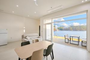 a living room with a table and a view of the water at Geoje The Shine Pool Villa in Geoje