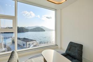 a living room with a large window overlooking the water at Geoje The Shine Pool Villa in Geoje
