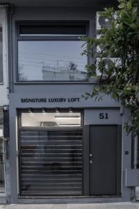 a building with a garage door with a sign that reads signature luxury lot at Signature Luxury Loft in Volos
