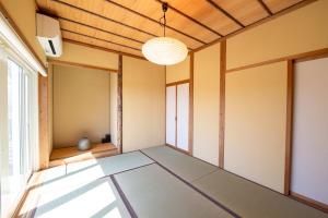 an empty room with a ceiling fan and a window at ReTune Hokuto in Hokuto