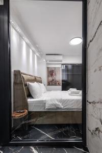 a mirror reflection of a bed in a room at Signature Luxury Loft in Volos